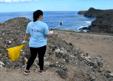 Colaboradora limpiando la playa