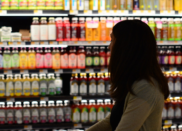 Consumidora frente a un lineal de bebidas