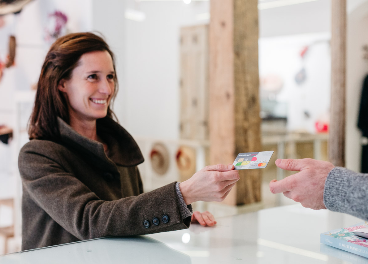 Mujer pagando con tarjeta en tienda